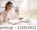 Young woman using a laptop, Work from the comfort of home, Use your laptop for work and communication, Work from home. 115814922