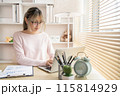 Young woman using a laptop, Work from the comfort of home, Use your laptop for work and communication, Work from home. 115814929