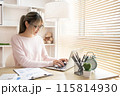 Young woman using a laptop, Work from the comfort of home, Use your laptop for work and communication, Work from home. 115814930