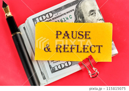 Conceptual pause and reflect symbol. Pause and reflect words written on a yellow piece of paper on dollars on a red background 115815075