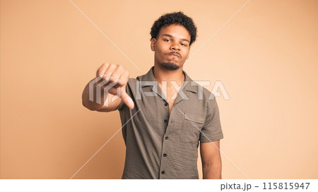Sad man making thumbs down sign and shaking head in displeasure 115815947