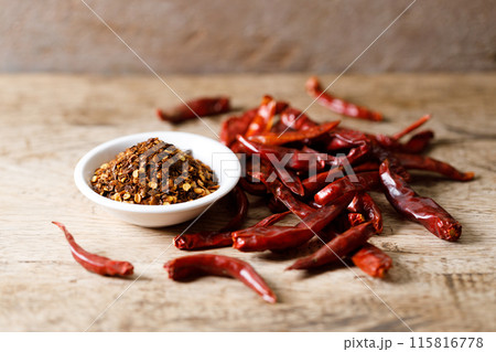 Dried red chilie and ground chilli on wooden table. 115816778