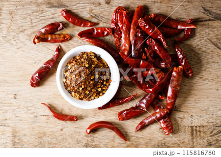 Dried red chilie and ground chilli on wooden table. Dried red chilie and ground chilli on wooden table. 115816780