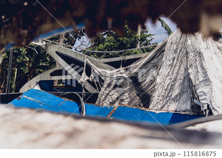 Old and rusty motor boats on a landfill surrounded by tropical forest 115816875