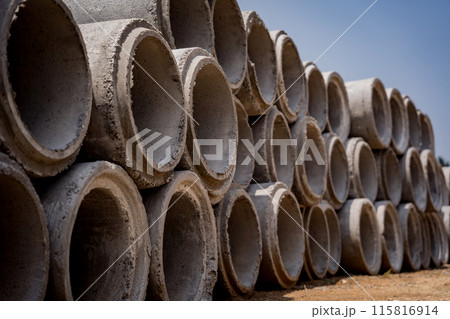 A stack of concrete ring pipes piled and creating a symmetrical arrangement 115816914