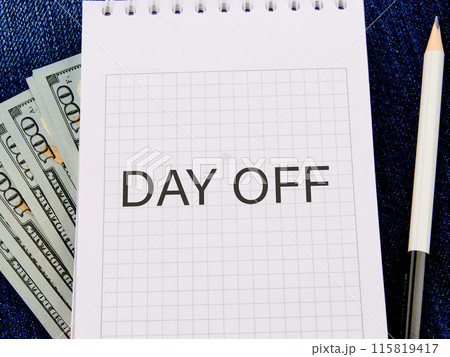 Business and Day off concept. Copy space. DAY OFF symbol in a notebook in a composition with American hundred dollar bills and a pencil Business and Day off concept. Copy space. DAY OFF symbol in a notebook in a composition with American hundred dollar bills and a pencil 115819417