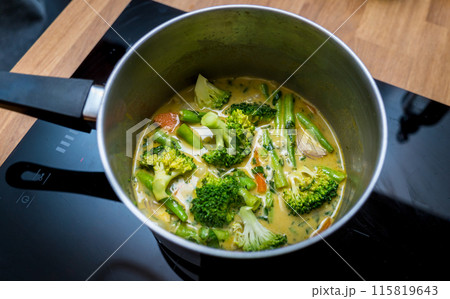 Chef at the kitchen preparing green curry with herbs and rice Chef at the kitchen preparing green curry with herbs and rice 115819643