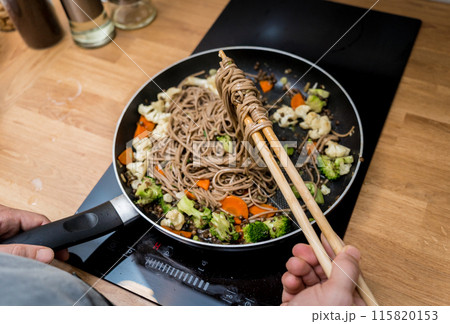 Chef at the kitchen preparing japanese buckwheat pasta with lentils Chef at the kitchen preparing japanese buckwheat pasta with lentils 115820153
