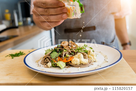 Chef at the kitchen preparing japanese buckwheat pasta with lentils 115820157
