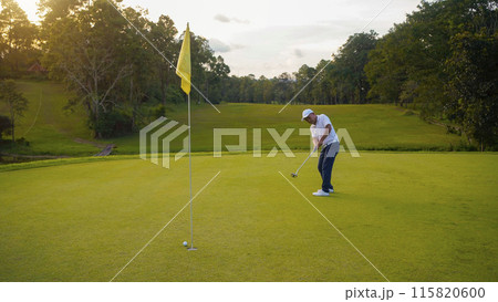Blurred golfer playing golf in the evening golf course, on sun set evening time. 115820600