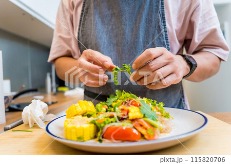 Chef at the kitchen preparing spicy glass noodle salad Chef at the kitchen preparing spicy glass noodle salad 115820706