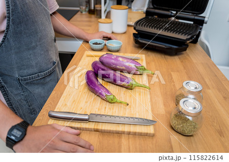 Chef at the kitchen preparing grilled eggplants with garlic Chef at the kitchen preparing grilled eggplants with garlic 115822614