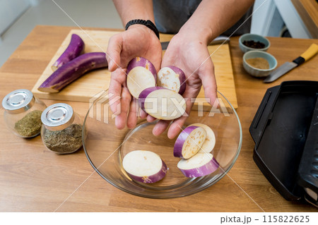 Chef at the kitchen preparing grilled eggplants with garlic 115822625