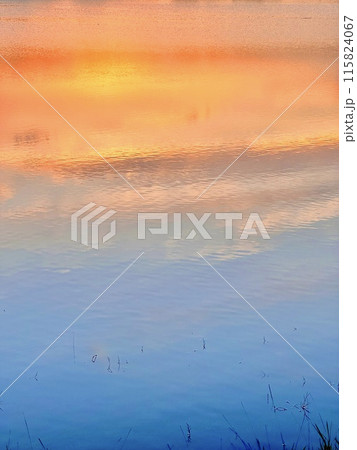 Reflection of the sunset in the lake, beautiful contrast of colors two tones for the best wallpaper and background.  115824067