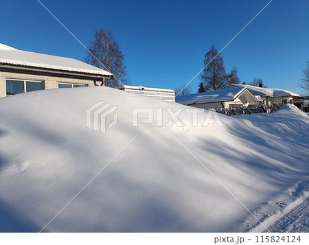 A day after the snowfall in the countryside. Sun is shining and casting shadows on the snowdrifts. Deep snow looking like a pillow. Negative degrees. Winter wonderland during January 115824124