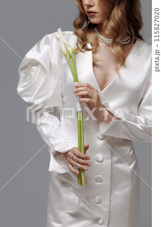A woman in a white dress with flowers on it poses for a photo 115827020