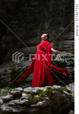 Asian girl in a beautiful red kimono in the middle of nature in a canyon 115827332