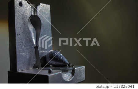 Sinker Molds. Lead fishing weights. A mold for casting a sinker in two parts and a finished product. 115828041