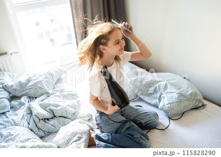 Cute Little Girl Drying Hair With A Hairdryer In Sleeping Room Cute Little Girl Drying Hair With A Hairdryer In Sleeping Room 115828290