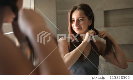 Young Girl Brushing And Braiding Her Hair In The Bathroom Mirror As Part Of Her Morning Routine 115828506