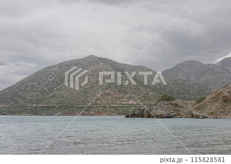 Mountain and seascape. Rocky seashore in cloudy weather Mountain and seascape. Rocky seashore in cloudy weather 115828581