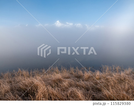 Fog in the morning and a view of the tops of snow-capped mountains Fog in the morning and a view of the tops of snow-capped mountains 115829380