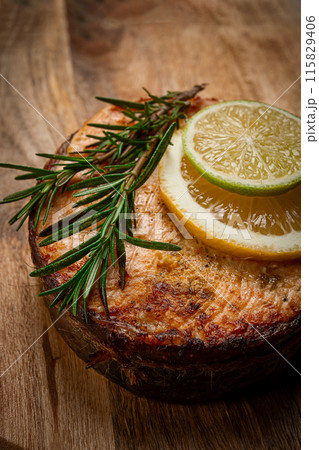 salmon steak, fried, on a cutting board, top view, rosemary, lemon and lime, homemade, one serving, no people, salmon steak, fried, on a cutting board, top view, rosemary, lemon and lime, homemade, one serving, no people, 115829406