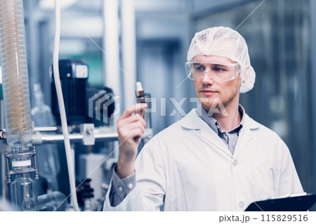Scientist in Science Lab proudly invented New Medicine Formula. Medical factory staff happy smiling with Concentrate Medical Extract from Plant. 115829516