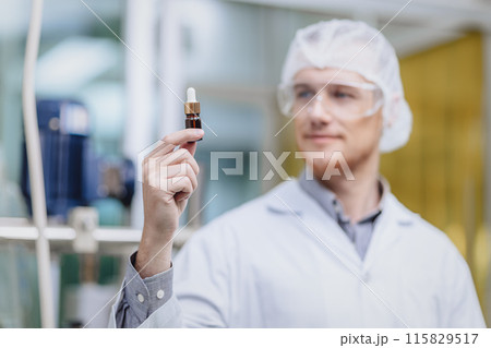 Scientist in Science Lab proudly invented New Medicine Formula. Medical factory staff happy smiling with Concentrate Medical Extract from Plant. 115829517