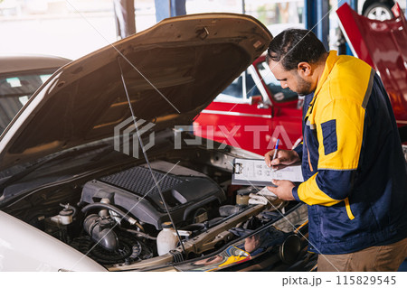 mechanic man checking engine open hood looking check list car maintenance service in garage workshop 115829545