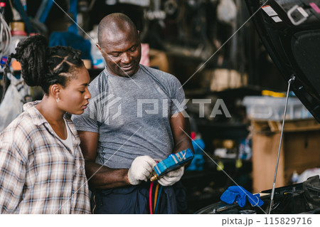 Mechanic man talking with customer inform explain car air condition low liquid problem, service detail in garage. Mechanic man talking with customer inform explain car air condition low liquid problem, service detail in garage. 115829716