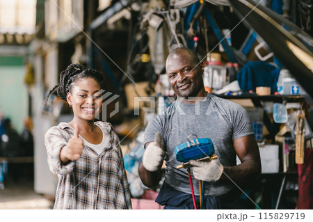 Happy customer standing Thumbs up with mechanic man fix car problem. Satisfied garage car service. 115829719