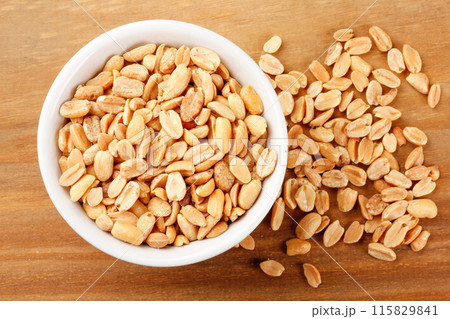 Roasted peeled peanuts in bowl on wooden table 115829841
