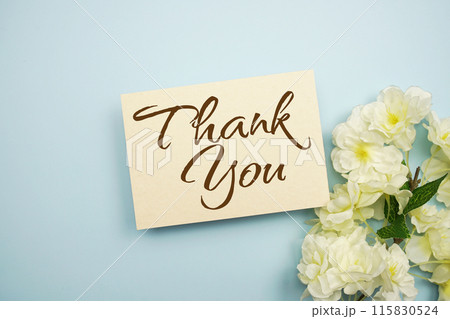 Thank You text message with flower decoration on blue background Thank You text message with flower decoration on blue background 115830524