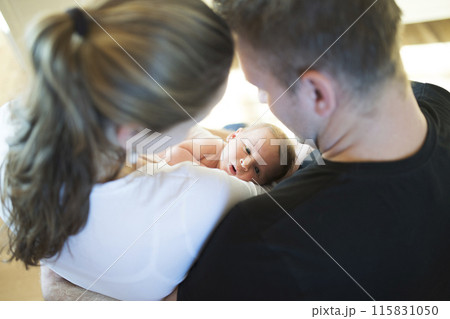 New parents holding newborn baby girl. Unconditional paternal love, idyllic family moment. New parents holding newborn baby girl. Unconditional paternal love, idyllic family moment. 115831050