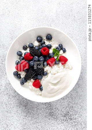 Cheese cottage with yogurt and fresh berries. Curd with blueberry, raspberry and blackberry, top view Cheese cottage with yogurt and fresh berries. Curd with blueberry, raspberry and blackberry, top view 115831274