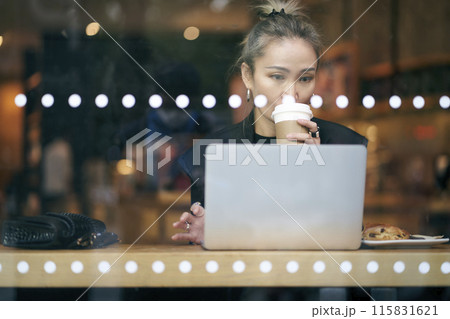 mid adult asian business woman working in coffee shop 115831621