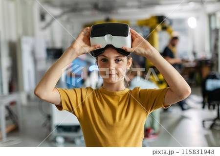 Portrait of schoolgirl with VR headset on head. Children learning robotics in Elementary school, using modern technology, virtual reality. 115831948