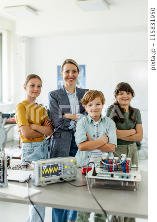 Children learning robotics in Elementary school. Young students building robot in after school robotics club. Field trip to real robotics laboratory. 115831950
