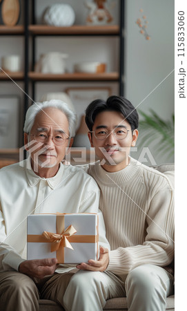 A son gives his father a gift, beautifully packaged in a box. Strong family ties 115833060