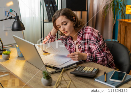 Tired exhausted woman analyzing paperwork graphs accounting payments calculating monthly expenses 115834383