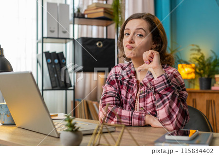 Businesswoman working on laptop computer at home office showing thumbs down sign dislike disapproval Businesswoman working on laptop computer at home office showing thumbs down sign dislike disapproval 115834402