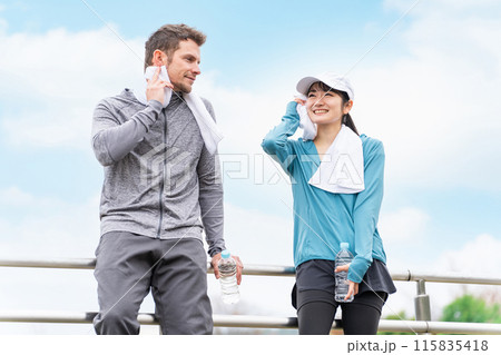 公園でジョギング・ウォーキング中に休憩・インターバルをとるスポーツウェアの男女 公園でジョギング・ウォーキング中に休憩・インターバルをとるスポーツウェアの男女 115835418