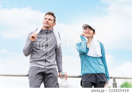 公園でジョギング・ウォーキング中に休憩・インターバルをとるスポーツウェアの男女 115835419