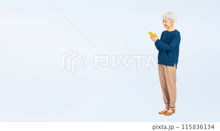 笑顔でスマホを使うシニア女性の全身写真 115836134