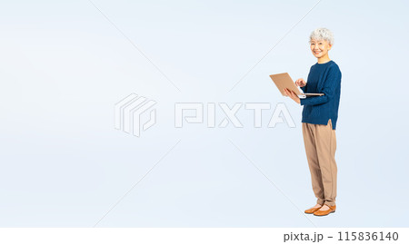ノートパソコンを使うシニア女性の全身写真 115836140