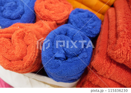 A storage basket made of wood filled with an assortment of towels A storage basket made of wood filled with an assortment of towels 115836230