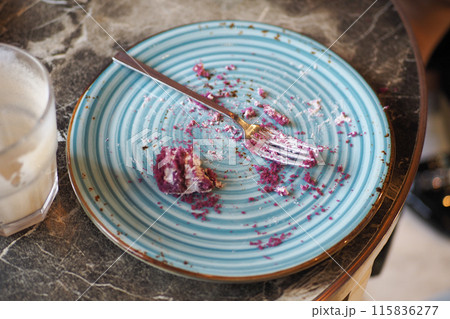 An empty dirty plate with a fork. 115836277