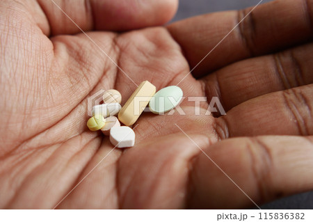 man holding many medical pills  115836382