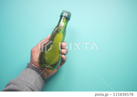 hand holding a bottle of olive oil  115836576